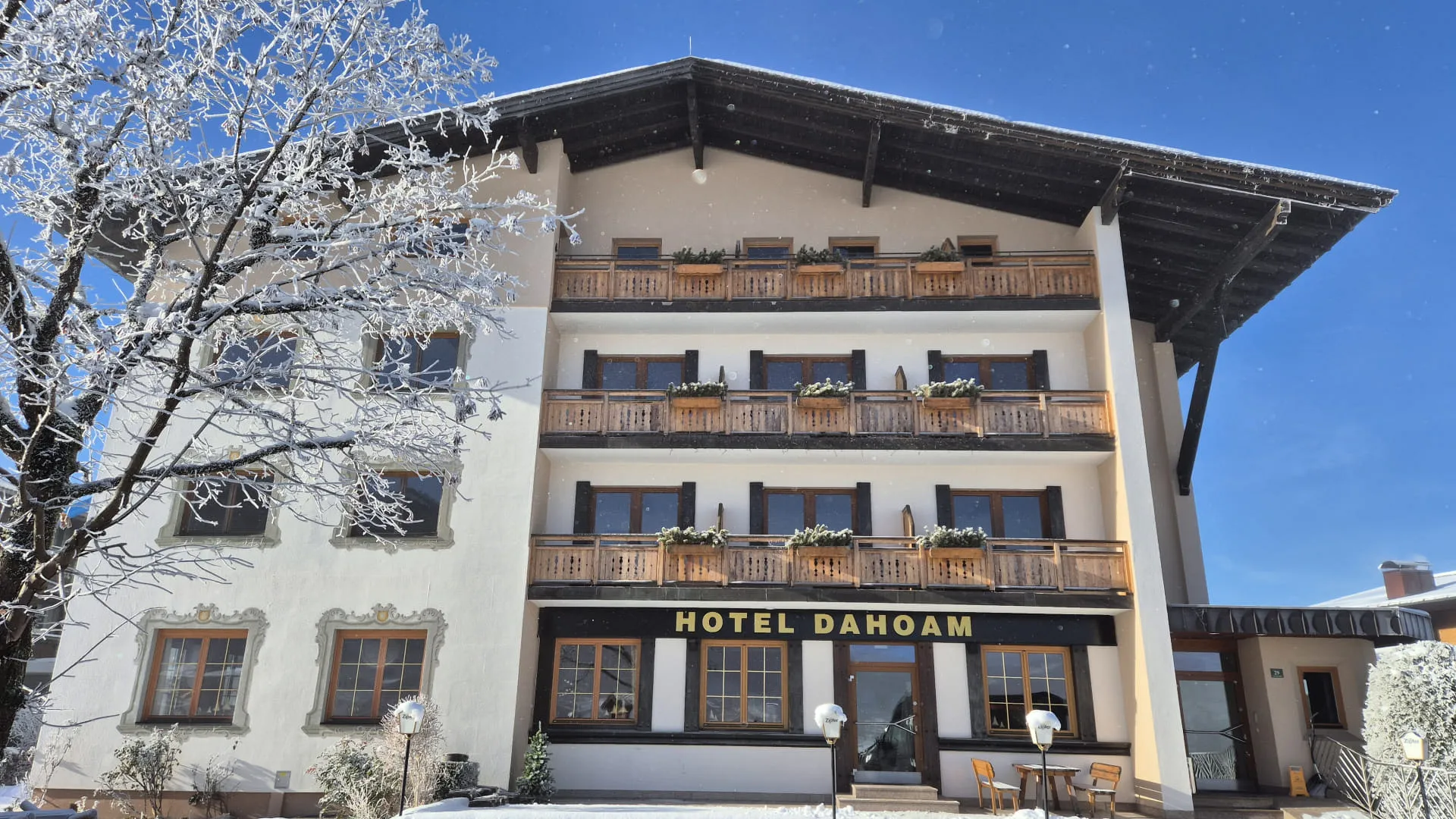 Hotel Dahoam im Winter mit schneebedeckten Bäumen