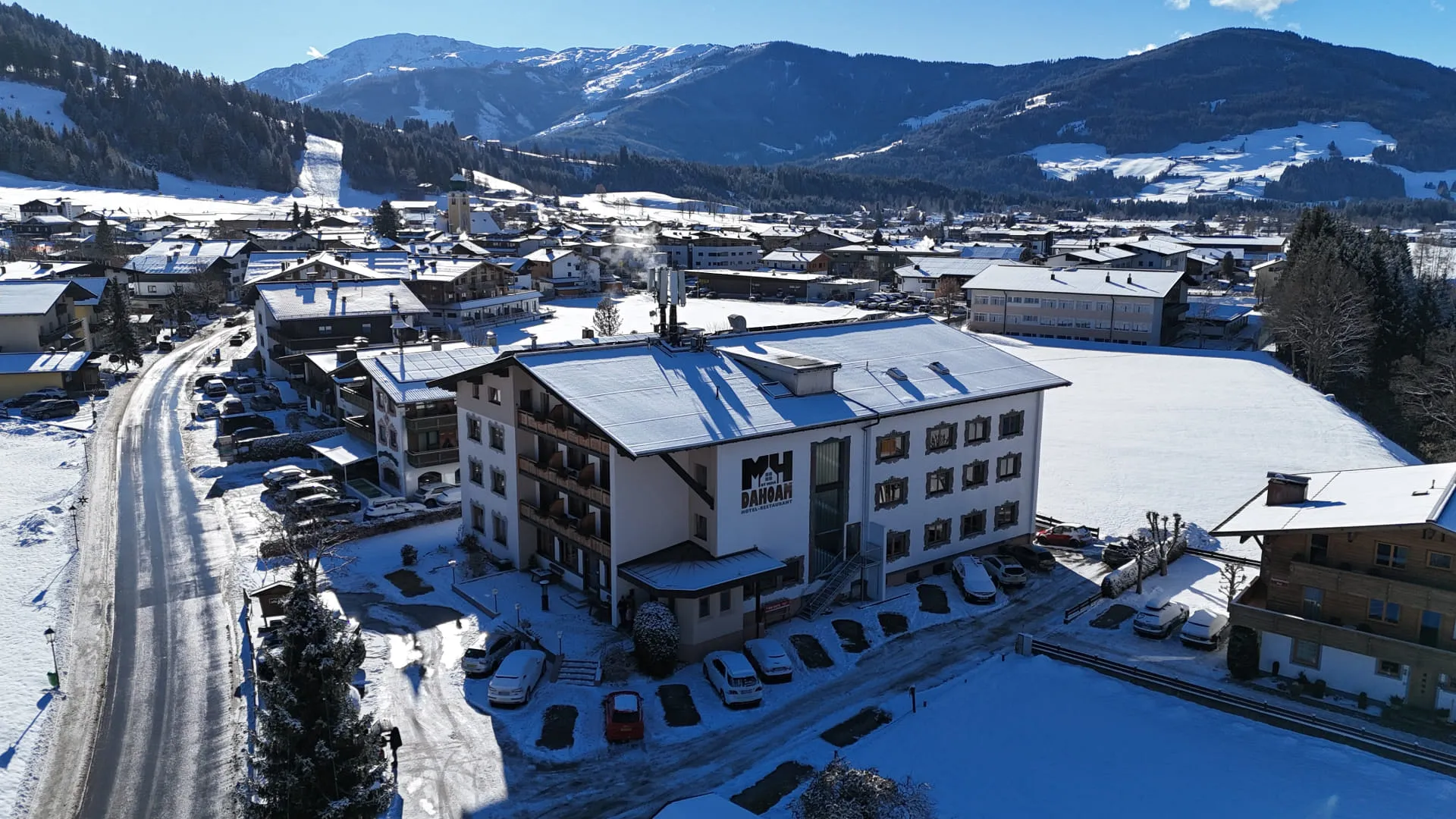 Schneebedeckte Landschaft mit einem Hotel und umliegenden Häusern