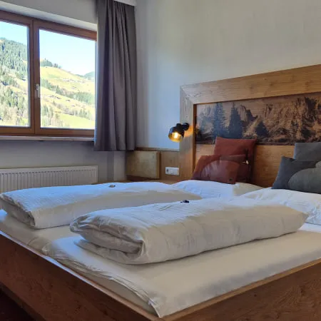 Helles Schlafzimmer mit Blick auf die Berge und Doppelbett