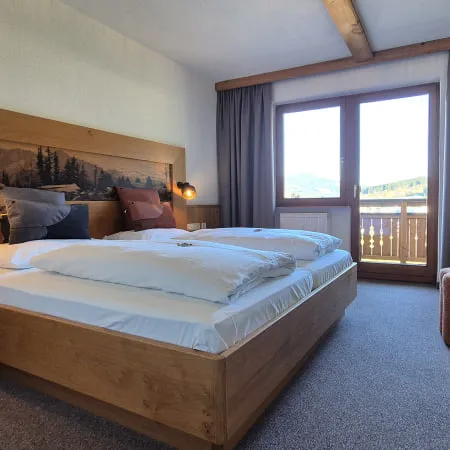 gemütliches Schlafzimmer mit großem Bett und Balkonblick
