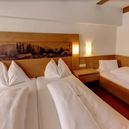 Dreibettzimmer mit Holzmöbeln und einem Gemälde an der Wand