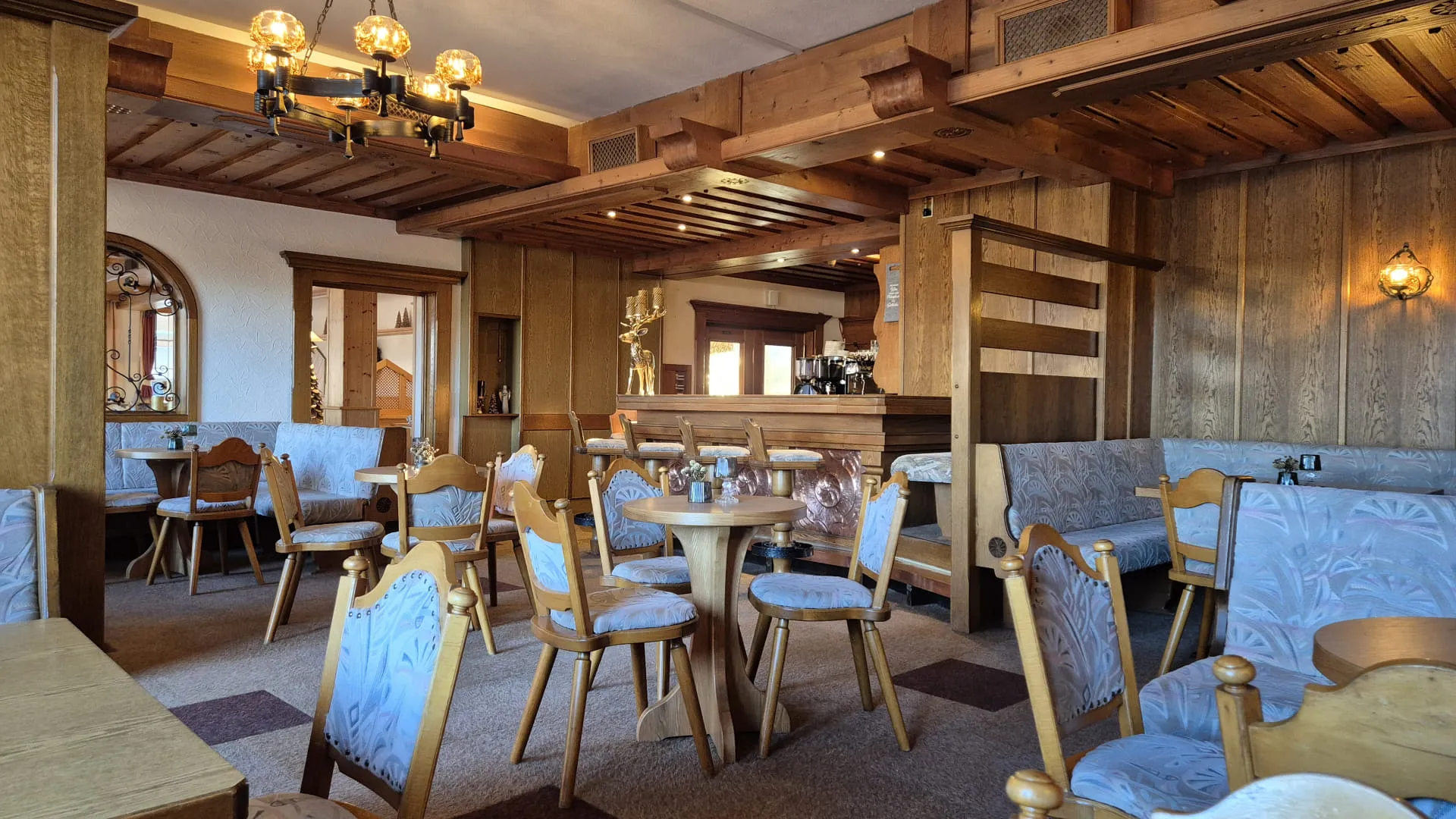 Gemütlicher Restaurantbereich mit Holzvertäfelung und Tischen.