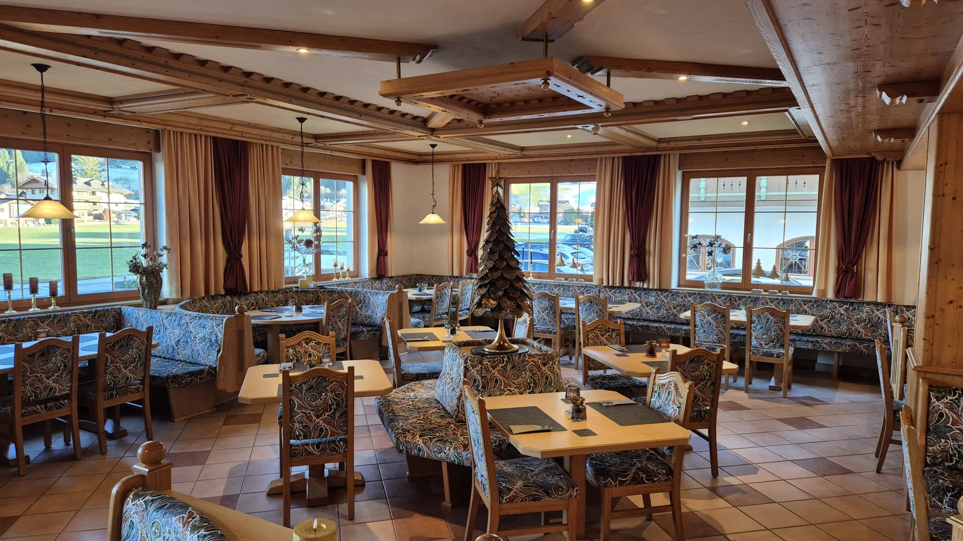 Interieur van een restaurant met houten decor en gezellige tafels.