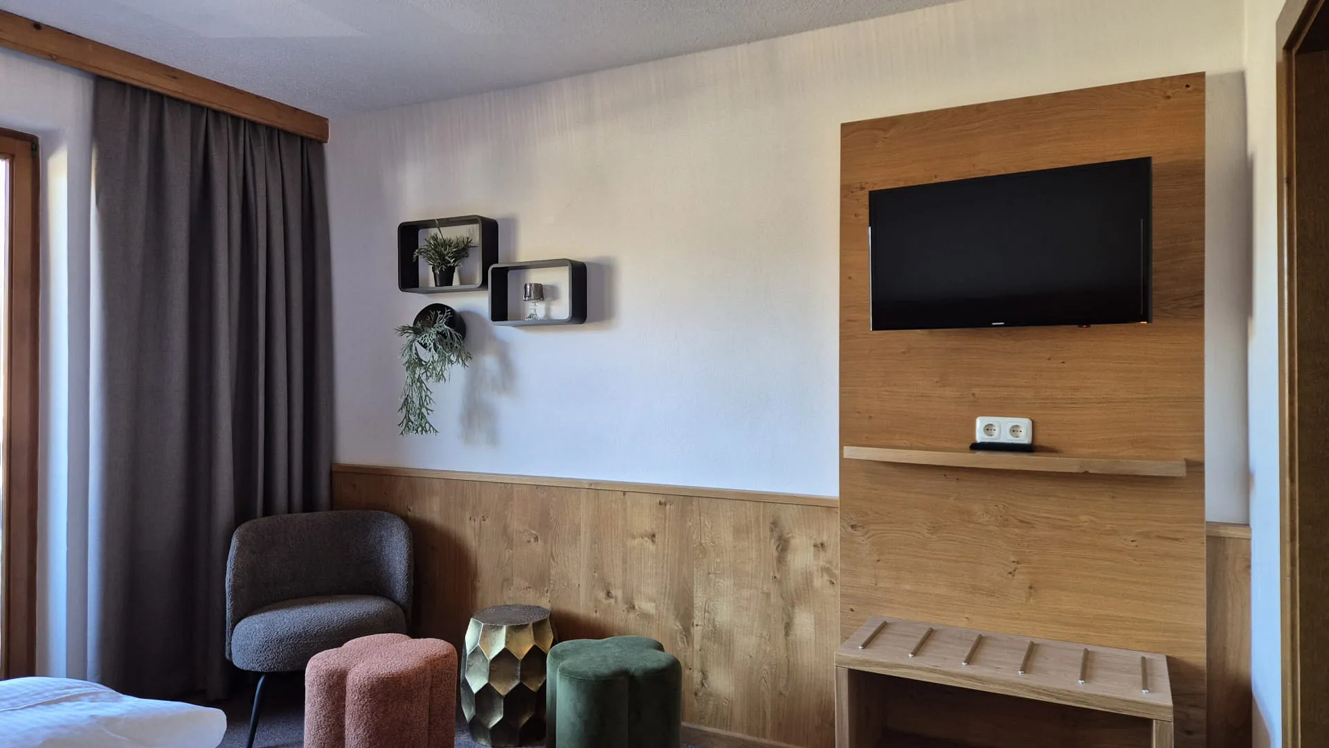 Gezellige kamer met een tv, comfortabele zitplaatsen en houten accenten