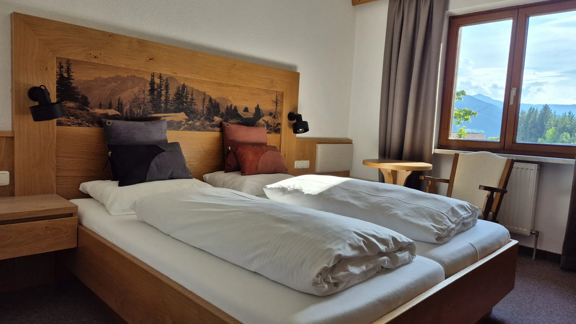 Helder slaapkamer met houten decor en bergzicht.