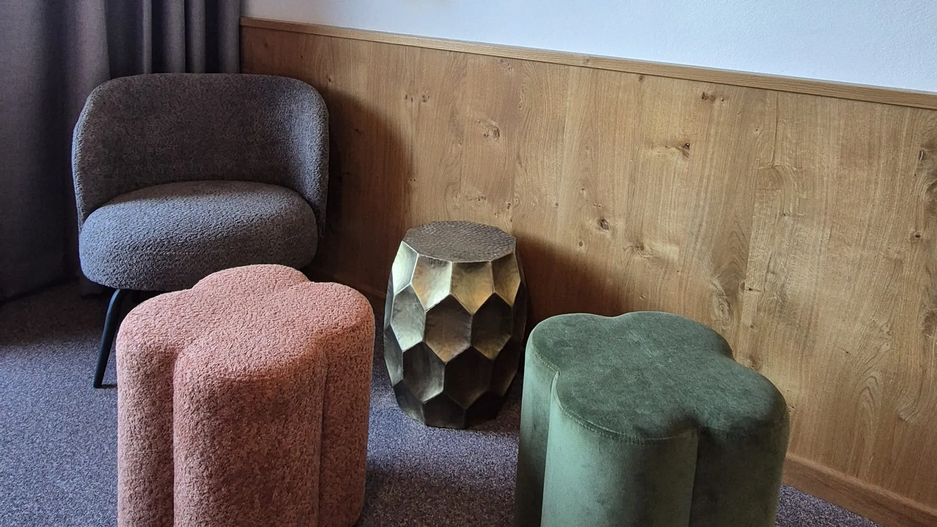 Stühle in einem Raum mit grauen Vorhängen und Pflanzenregalen an der Wand.