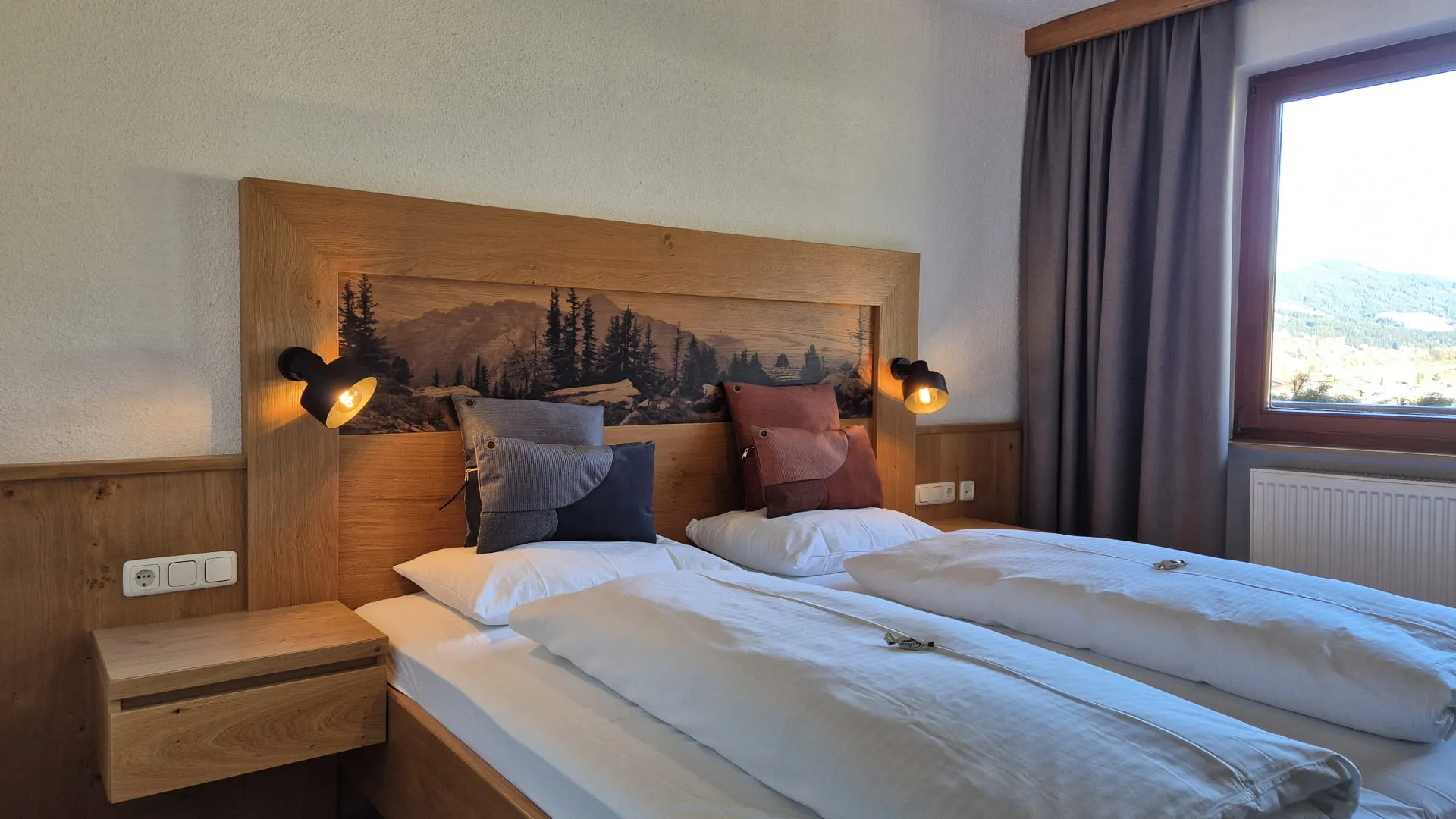 A comfortable sleeping area with two beds and wooden features.