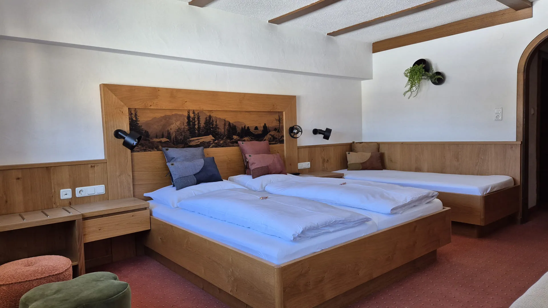 Helle Schlafzimmer mit zwei Betten und Holzverkleidung, gemütlicher Sitzecke.