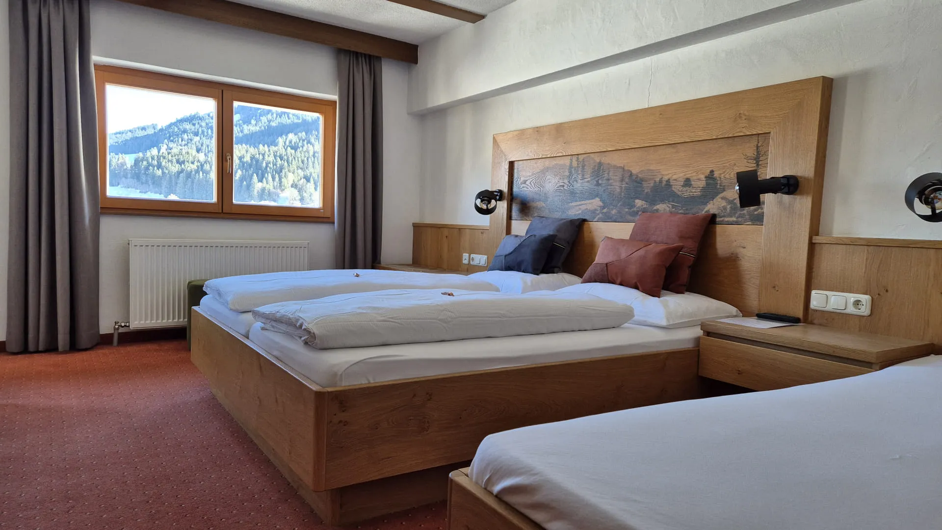 Hotellzimmer mit zwei Betten und Bergblick von den Fenstern