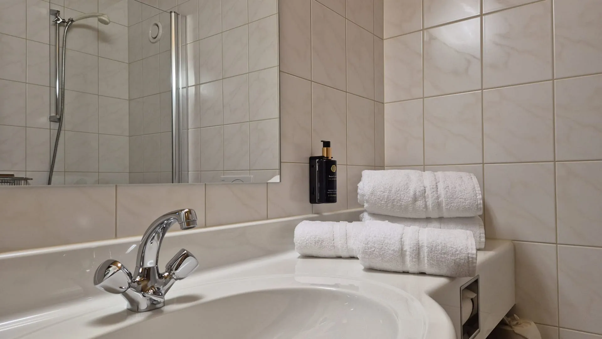 Badkamer met bad, handdoeken en spiegel