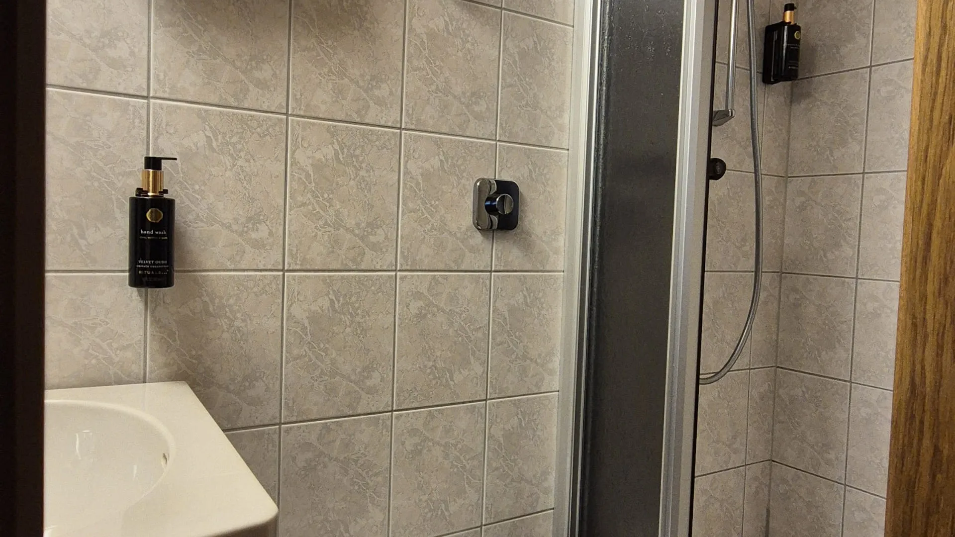 Bathroom with shower, toilet, and towels on the wall.